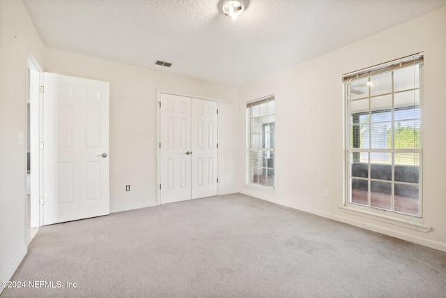 unfurnished bedroom with multiple windows and light colored carpet