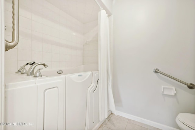 bathroom featuring toilet, a shower with curtain, and tile patterned floors