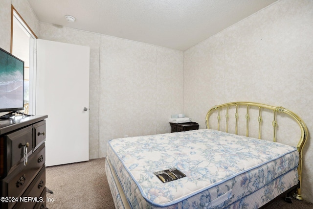 carpeted bedroom with a textured ceiling