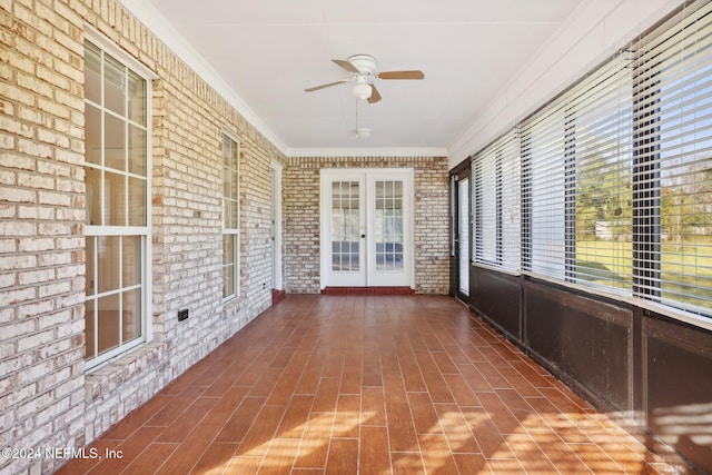 unfurnished sunroom with a wealth of natural light, french doors, and ceiling fan