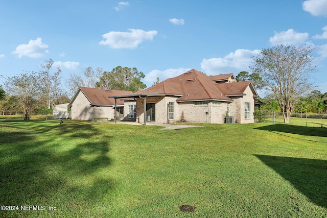 rear view of house with a patio area, a lawn, and cooling unit