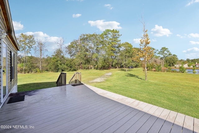 deck with a yard and a water view