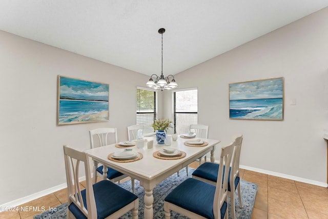 dining area with a chandelier, tile patterned floors, and vaulted ceiling