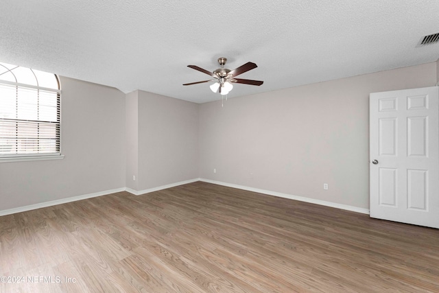 empty room with a textured ceiling, wood-type flooring, and ceiling fan