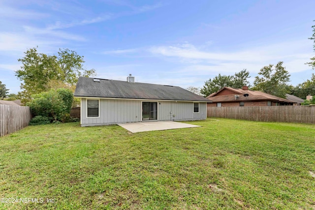 rear view of house with a lawn and a patio area