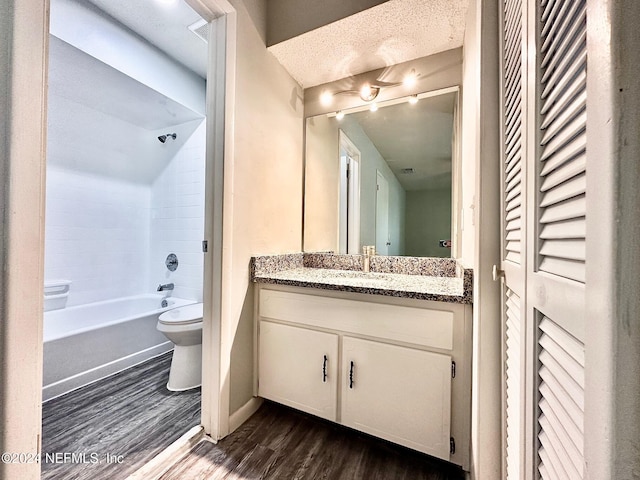 full bathroom with a textured ceiling, toilet, shower / tub combination, vanity, and hardwood / wood-style flooring