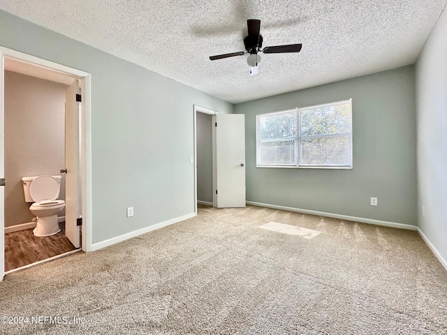 unfurnished bedroom featuring light carpet, a textured ceiling, ensuite bath, and ceiling fan