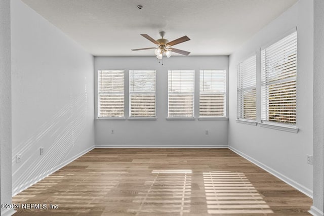 empty room with light hardwood / wood-style flooring, ceiling fan, and plenty of natural light