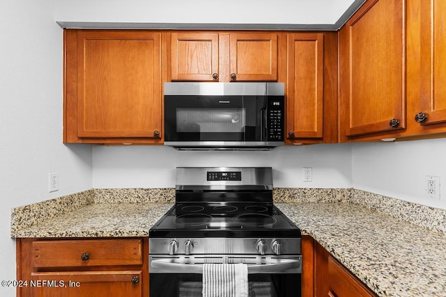 kitchen featuring light stone countertops and stainless steel appliances