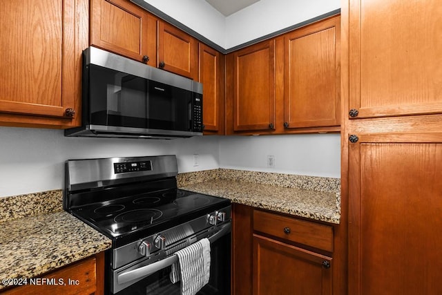 kitchen with appliances with stainless steel finishes and light stone countertops