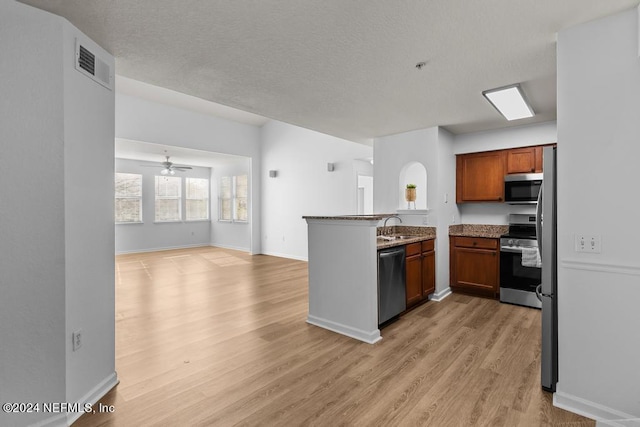 kitchen with sink, kitchen peninsula, light hardwood / wood-style floors, stainless steel appliances, and ceiling fan