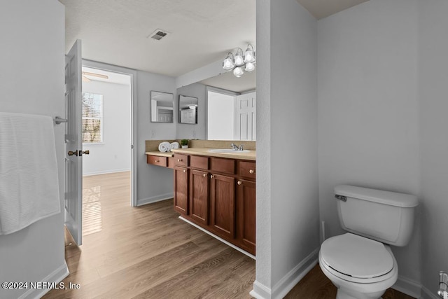 bathroom featuring toilet, hardwood / wood-style flooring, and vanity