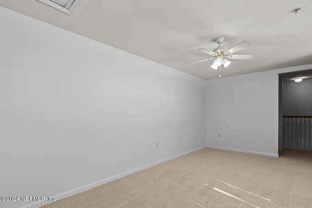 spare room featuring light carpet and ceiling fan