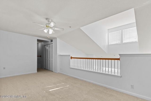 bonus room featuring vaulted ceiling, light carpet, and ceiling fan