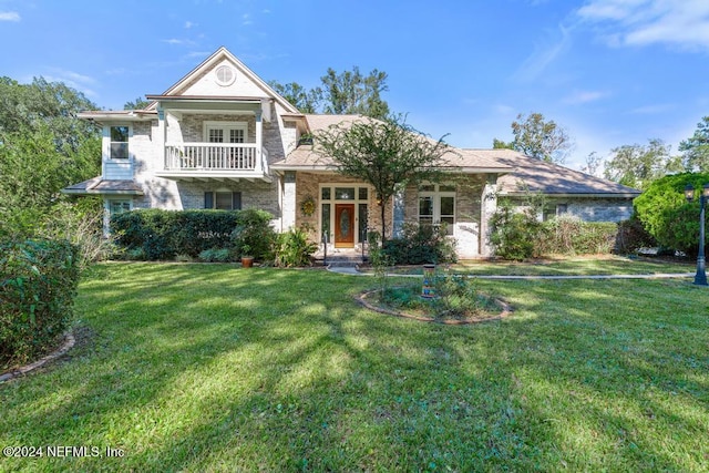 view of front of house with a front yard and a balcony