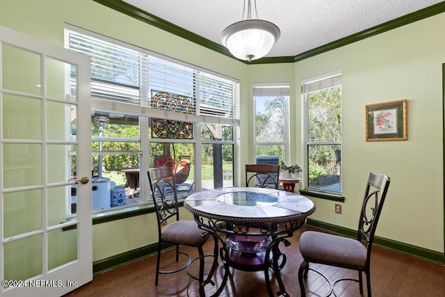 dining area with ornamental molding, dark wood-type flooring, a textured ceiling, and french doors