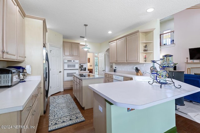 kitchen featuring dark hardwood / wood-style flooring, a kitchen island, a textured ceiling, plenty of natural light, and white appliances