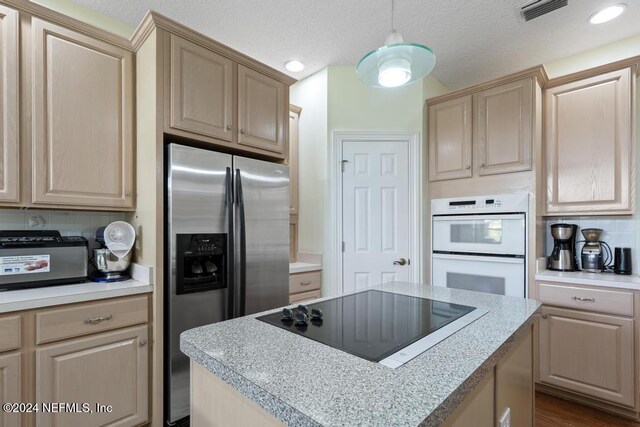 kitchen with a center island, black electric cooktop, pendant lighting, white double oven, and stainless steel refrigerator with ice dispenser