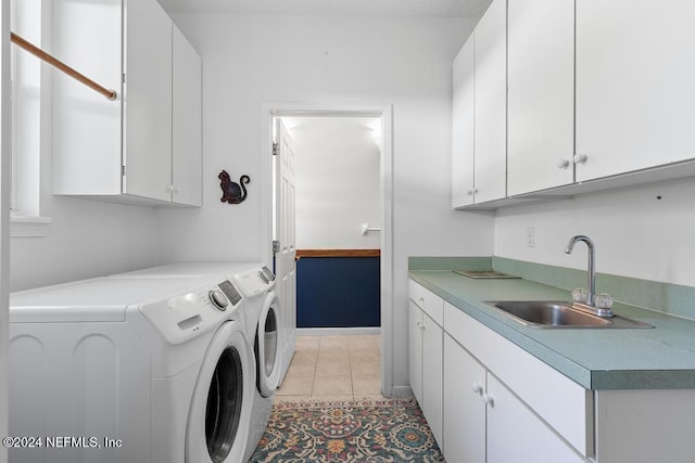 washroom featuring cabinets, sink, washer and clothes dryer, and light tile patterned floors