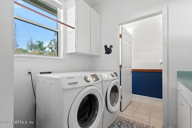 clothes washing area featuring independent washer and dryer, cabinets, and light tile patterned floors