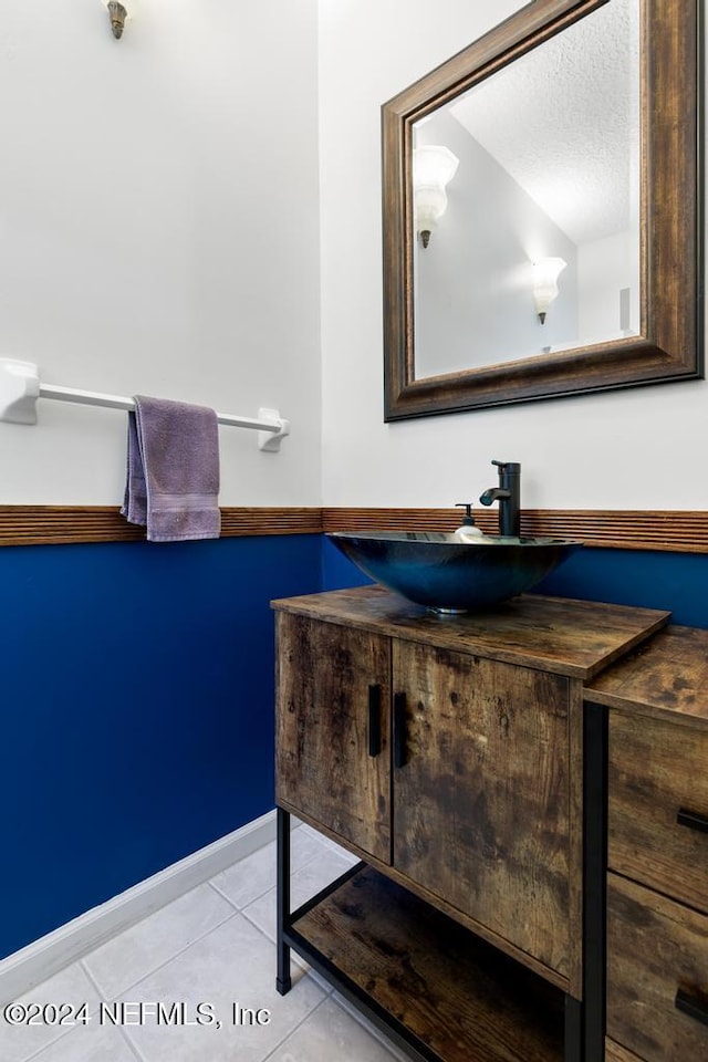 bathroom with vanity, a textured ceiling, and tile patterned flooring