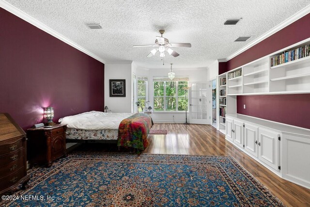 unfurnished bedroom with ceiling fan, a textured ceiling, ornamental molding, and dark hardwood / wood-style flooring