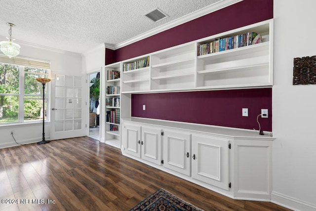 unfurnished living room featuring ornamental molding, a textured ceiling, and dark hardwood / wood-style flooring