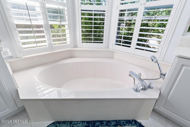 bathroom featuring a healthy amount of sunlight, a bath, and tile patterned flooring