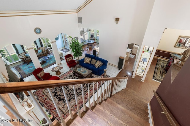 stairway with a high ceiling and wood-type flooring