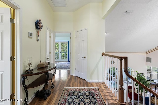 hall featuring a towering ceiling, french doors, and dark hardwood / wood-style floors