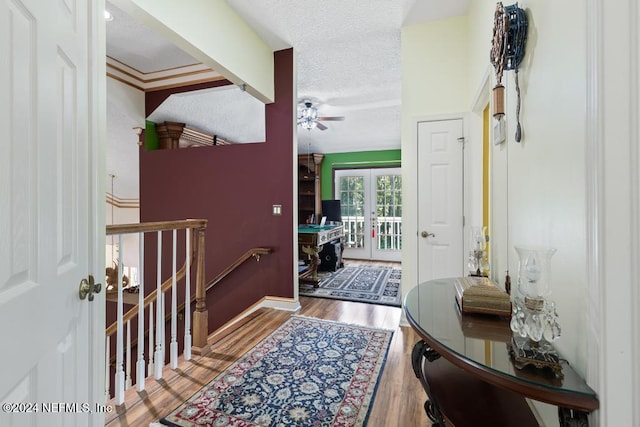 entrance foyer with ornamental molding, a textured ceiling, hardwood / wood-style flooring, and ceiling fan