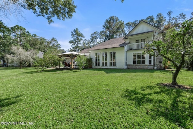 back of house with a gazebo, a lawn, and a balcony