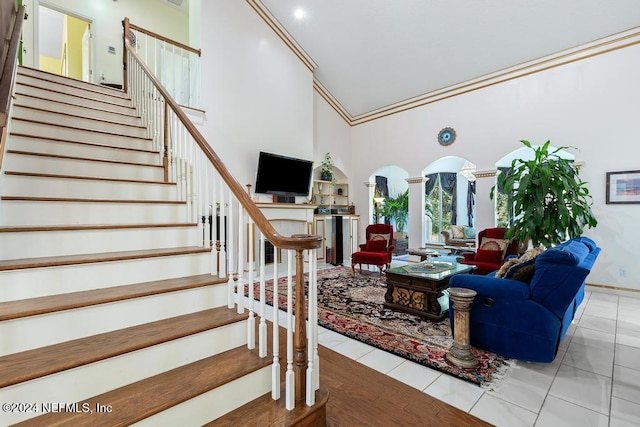 living room featuring ornamental molding, high vaulted ceiling, ornate columns, and light tile patterned floors