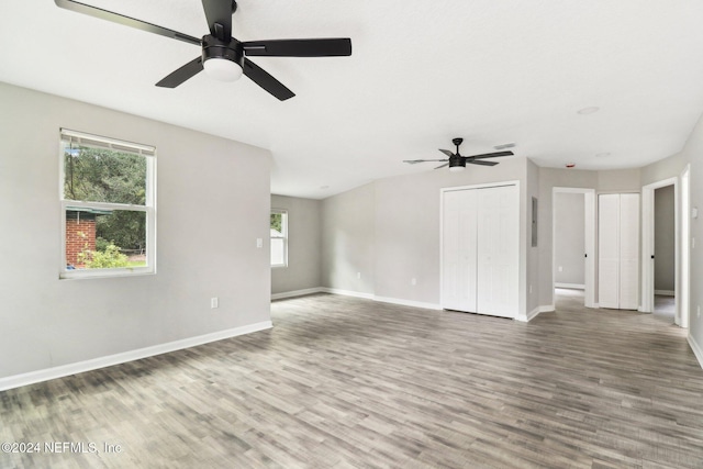 unfurnished living room with wood-type flooring and ceiling fan