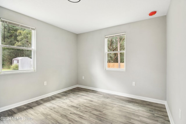 spare room with a wealth of natural light and hardwood / wood-style flooring