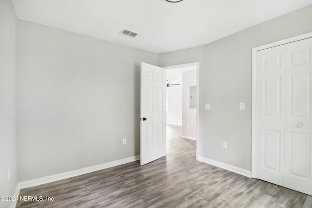 unfurnished bedroom with hardwood / wood-style floors and a closet