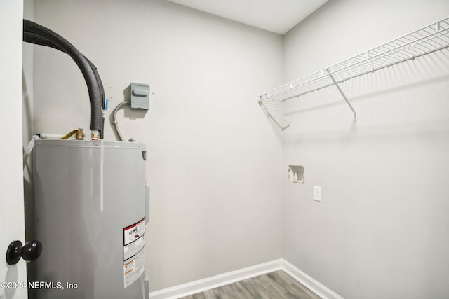 laundry area featuring hardwood / wood-style floors and water heater