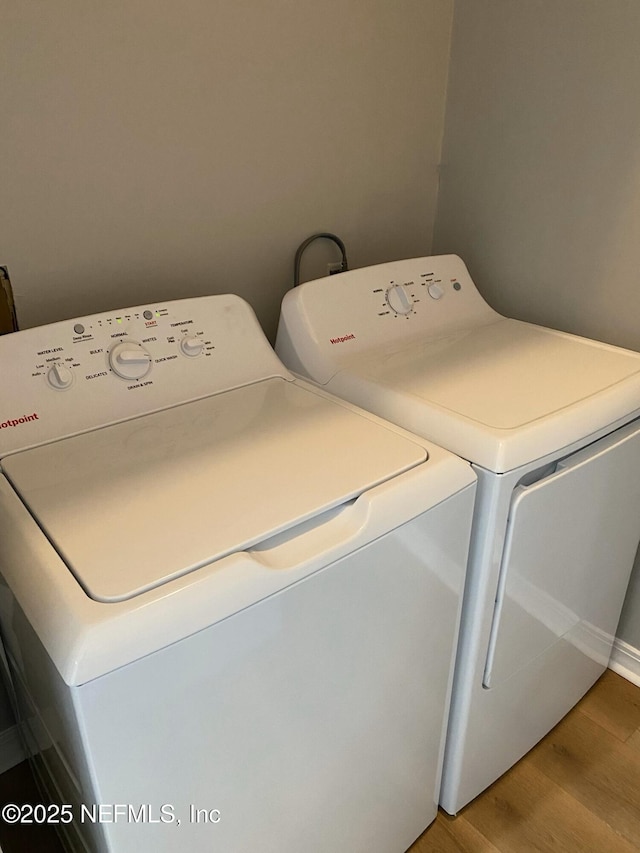 laundry area with hardwood / wood-style floors and washer and clothes dryer