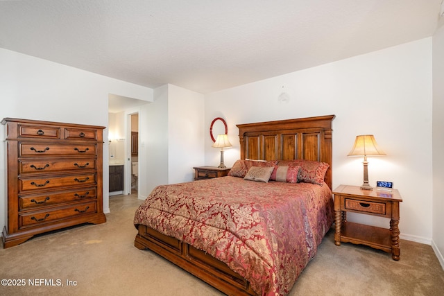 bedroom featuring light colored carpet and connected bathroom