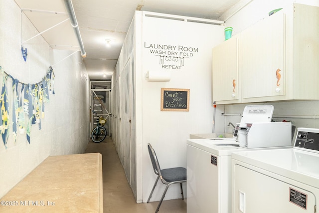 clothes washing area with cabinets and washing machine and clothes dryer