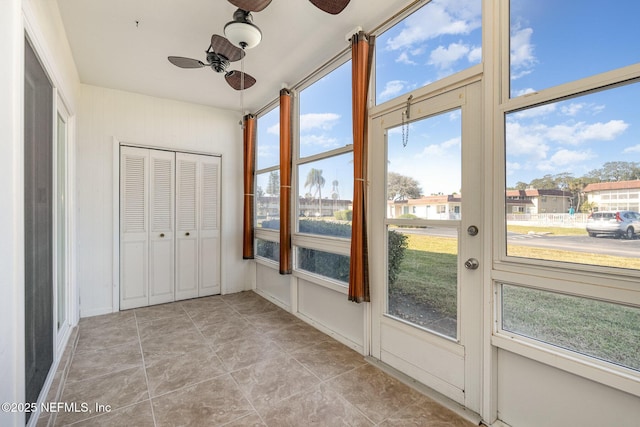 unfurnished sunroom featuring ceiling fan