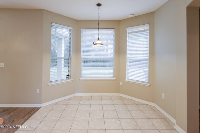 unfurnished dining area featuring light hardwood / wood-style floors and plenty of natural light