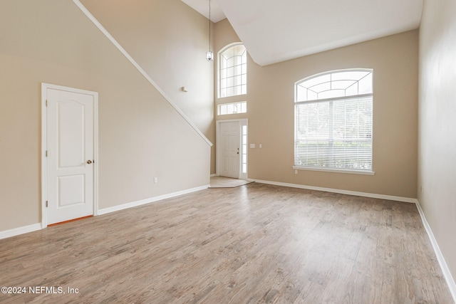 interior space with light hardwood / wood-style flooring and a high ceiling