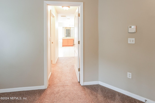 hallway featuring light colored carpet