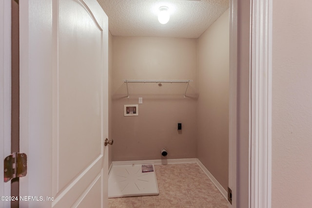 washroom with hookup for a washing machine, hookup for an electric dryer, and a textured ceiling