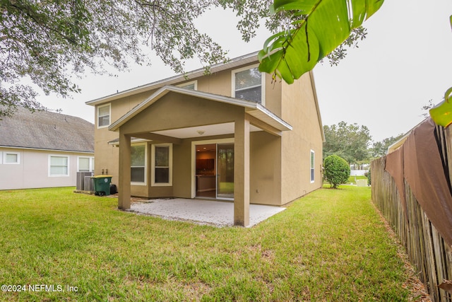 back of house featuring a lawn, central AC, and a patio area