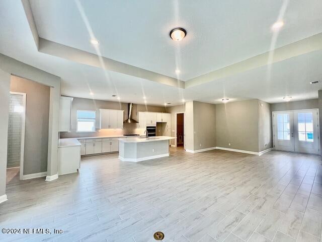 unfurnished living room featuring french doors, light hardwood / wood-style floors, and sink