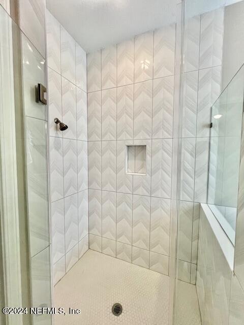 bathroom with a shower with door