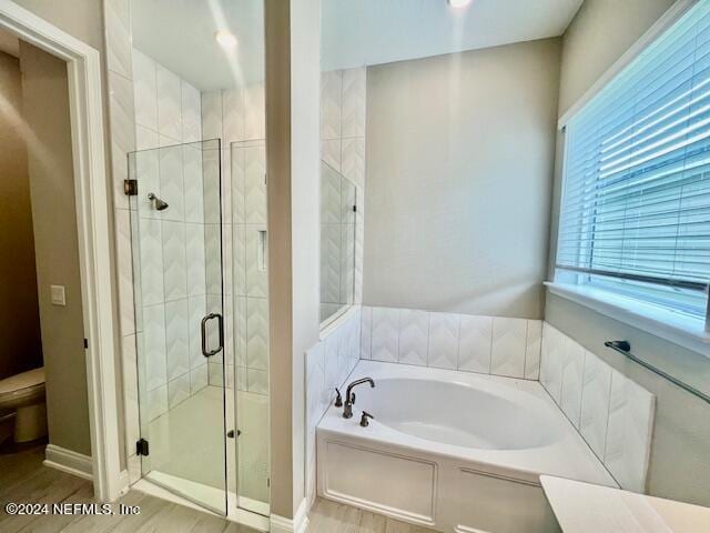 bathroom with hardwood / wood-style flooring and independent shower and bath