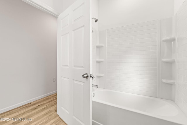 bathroom with tiled shower / bath combo and hardwood / wood-style flooring